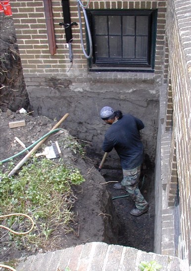 Weep drain to storm sewer is flushed before new drain line is attached. Note hose. Storm conduits removed and plugged