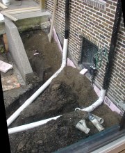 Two conduits are connected. Pea gravel and rigid basement insulation are in place.
