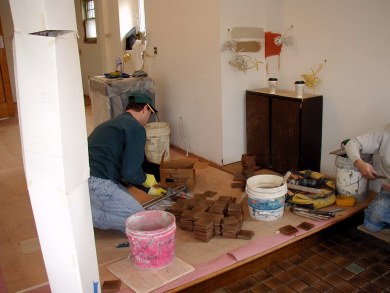 Cutting tiles to fit the edges.