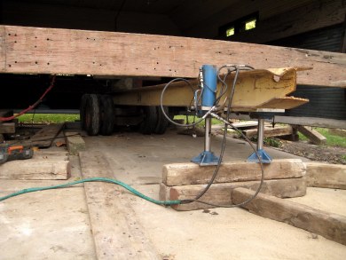Jacks raising beams attached to garage